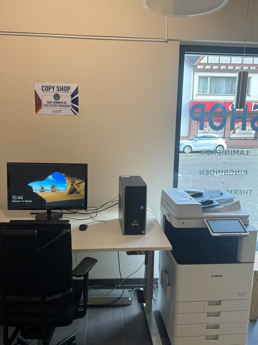 Selbstbedienungs-PC mit Monitor und Tastatur, daneben ein Canon-Multifunktionsdrucker